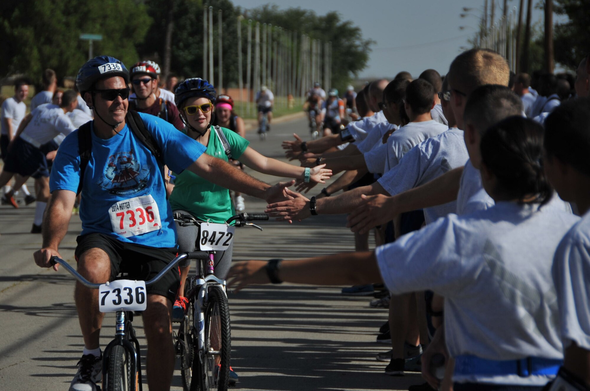 Brig. Gen. Scott Kindsvater, 82nd Training Wing Commander, exchanges high-fives with Airmen-in-Training as he passes through Airmen’s Alley during the Hotter’N Hell bike race Aug. 23, 2014. Airmen’s Alley was filled with hundreds of AiT’s from different training Squadrons who cheered on the thousands of bikers riding through Sheppard Air Force Base, Texas. (U.S. Air Force photo/Airman 1st Class Robert L. McIlrath)
