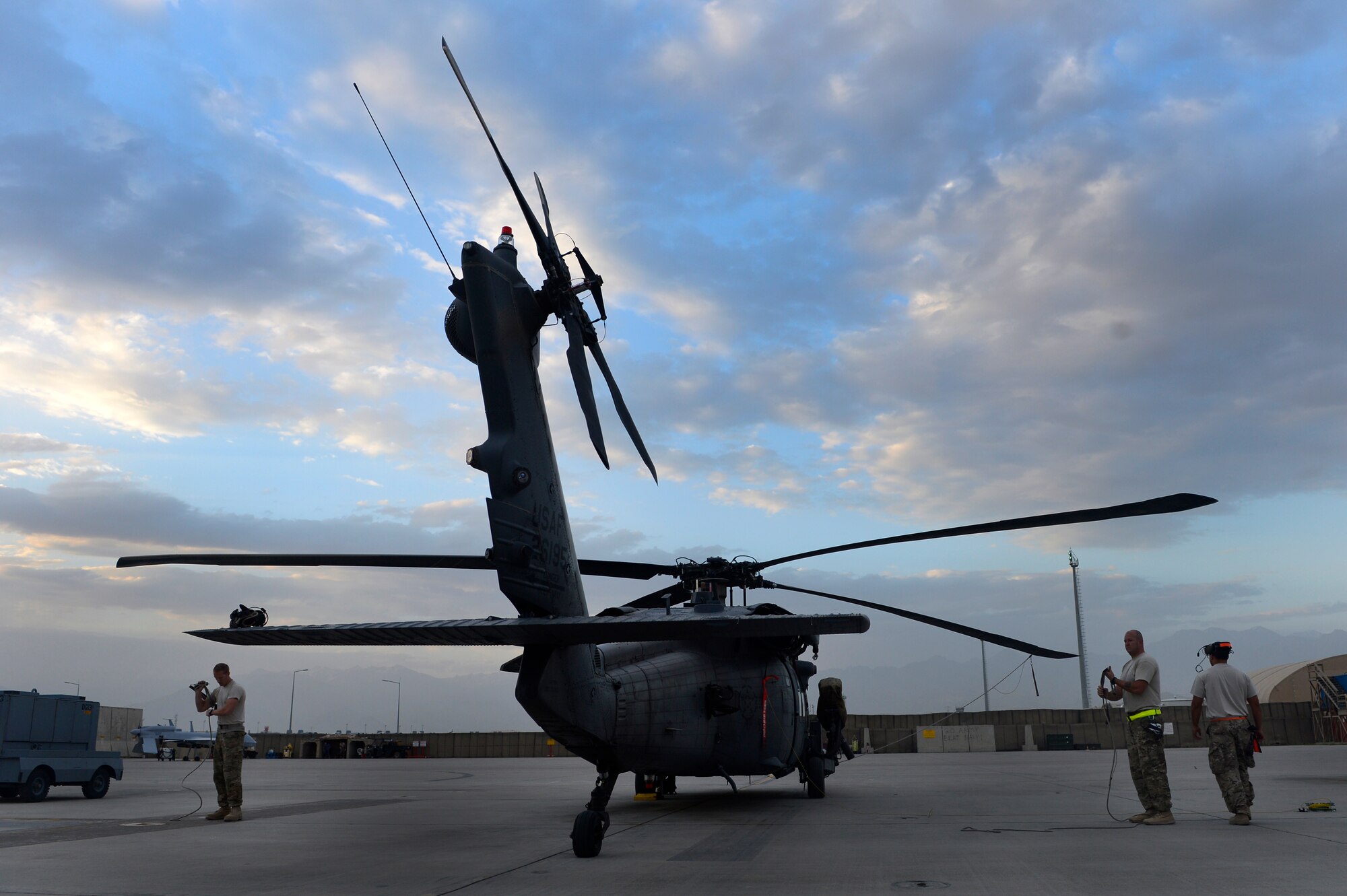 Airmen from the 455th Expeditionary Aircraft Maintenance Squadron prep an HH-60G Pave Hawk helicopter for flight at Bagram Air Field, Afghanistan, July 9, 2014. The maintenance team is deployed from the 923rd Aircraft Maintenance Squadron, Davis-Monthan Air Force Base, Arizona. (U.S. Air Force photo by Senior Airman Sandra Welch/Released)