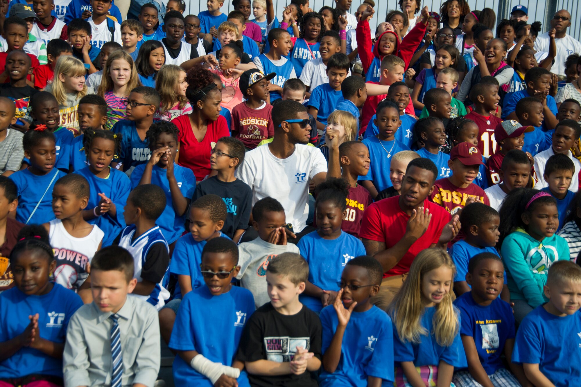 Members of the Youth Age Program await the arrival of the Washington Redskins August 22, 2014 at Joint Base Andrews.  The team performed a walk-through practice and signed autographs for military members and their families as part of their Redskins Salute effort. (U.S. Air Force photo/Staff Sgt. Robert Cloys)