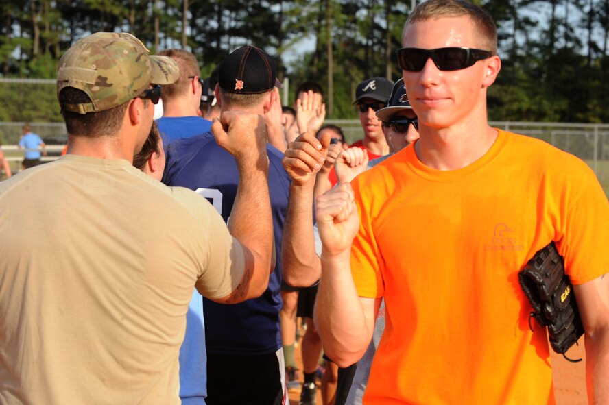 Members of the Company Grade Officer Group and Shaw’s Rising IV “high-five” each other after a softball game held during Shaw’s family fun night at Shaw Air Force Base, S.C., Aug. 21, 2014.  During the event, members of the Rising IV, 5/6, Top Three, Chiefs Group, CGO group, and base leadership, participated in softball games. (U.S. Air Force photo by Airman 1st Class Michael Cossaboom/Released)
