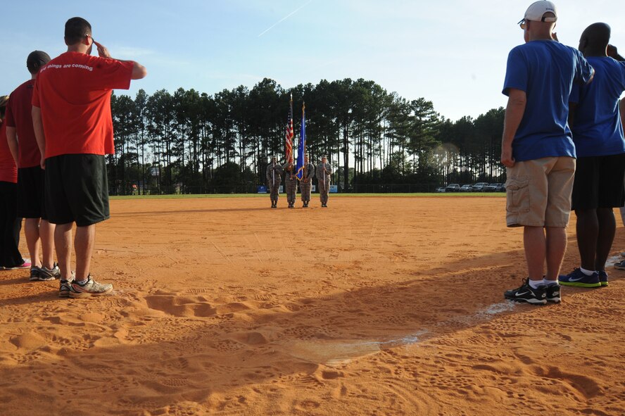 Members of Shaw’s squadron, group, and wing leadership (left), and Chiefs Group (right), salute the U.S. flag before a softball game at Shaw Air Force Base, S.C., Aug. 21, 2014. During Shaw’s family fun night, the final event was a softball game between Shaw’s Chiefs Group and base leadership. U.S. Air Force Maj. Gen. H. D. Polumbo Jr., Ninth Air Force commander, threw the first pitch of the game. (U.S. Air Force photo by Airman 1st Class Michael Cossaboom/Released) 