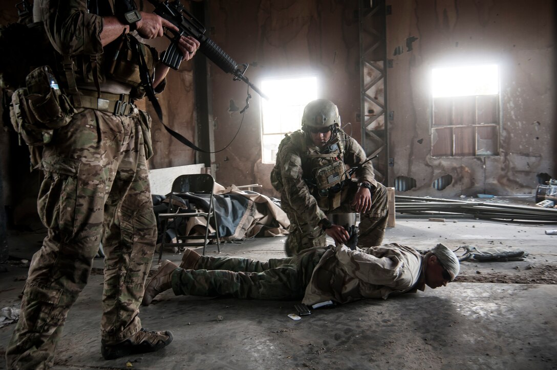 Staff Sgt. Devon Kuny and Tech. Sgt. Brent Beckner, joint tactical air controllers from the 148th Air Support Operations Squadron, Annville, Pa., secure a simulated prisoner while conducting a high-value target objective during Operation Northern Strike 2014 near Rogers City, Mich., on Aug. 6, 2014. Operation Northern Strike 2014 is a joint multi-national combined arms training exercise conducted in Michigan. (U.S. Air National Guard photo by Master Sgt. Scott Thompson/released)