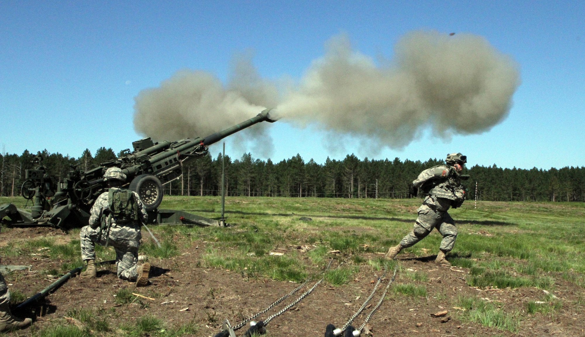 Soldiers assigned to gun two, Bravo Battery, 1st Battalion, 119th Artillery Regiment, Michigan National Guard, fire the M777A1 howitzer during the eXportable Combat Training Capability Exercise held at the Camp Grayling Joint Maneuver Training Center, Mich., July 18, 2014. (U.S. Army photo by Sgt. Jeremy Miller/Released)