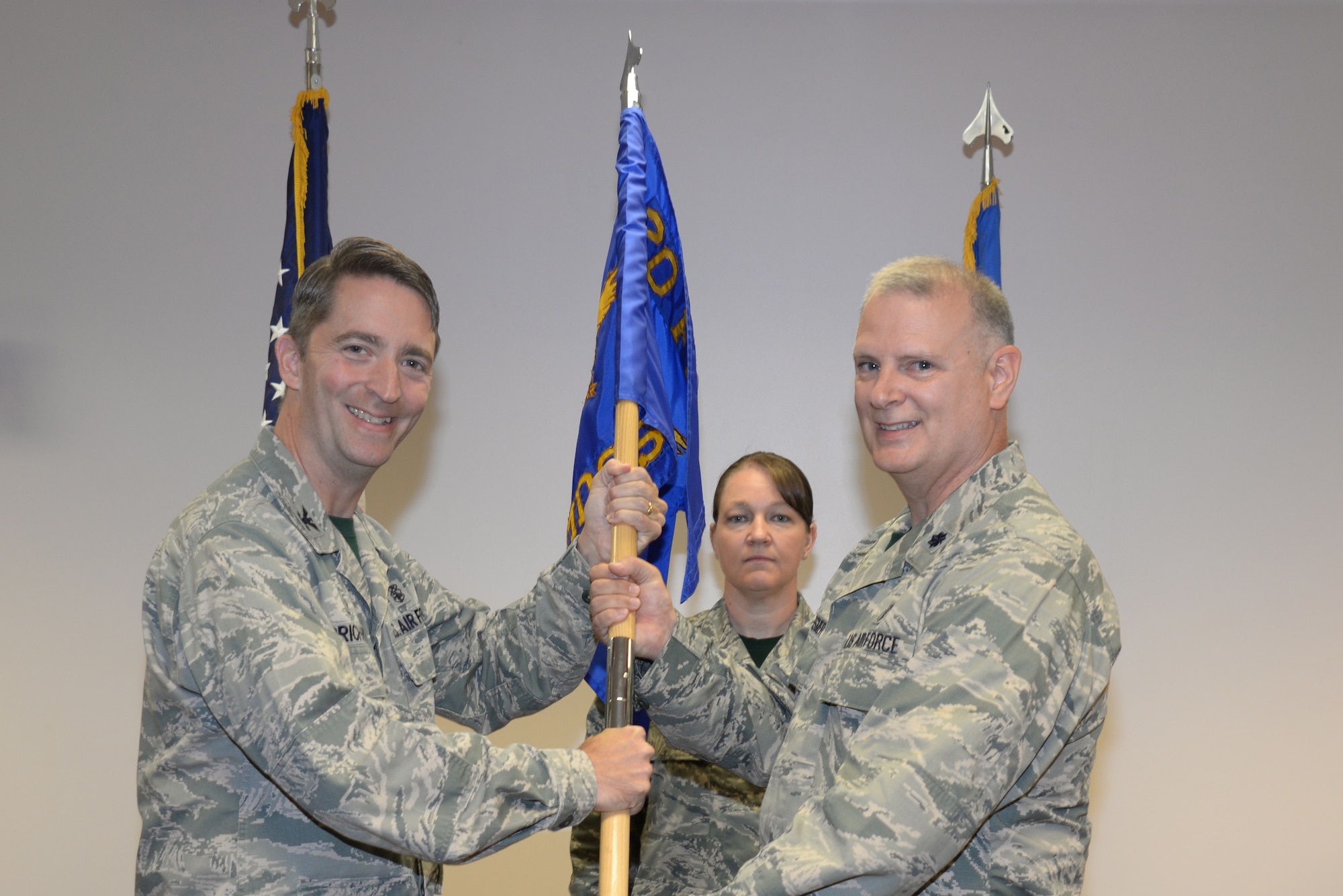 U.S. Air Force Lt. Col. Daniel Bessmer, 20th Medical Support Squadron commander (right), receives the 20th MDSS guidon from Col. Curt Prichard, 20th Medical Group commander, during a change of command ceremony at Shaw Air Force Base, S.C., Aug. 22, 2014. The symbolic tradition of passing the guidon has survived through military history and remains the key event during a change of command ceremony. (U.S. Air Force photo by Airman 1st Class Michael Cossaboom/Released)