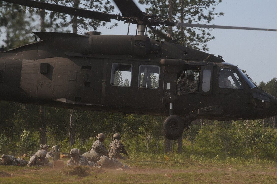 Soldiers assigned to Bravo Battery, 1st Battalion, 119th Artillery Regiment, Michigan National Guard, provide security in a hot landing zone after dismounting a UH-60 Black Hawk during the eXportable Combat Training Capability Exercise held at the Camp Grayling Joint Maneuver Training Center, Mich., July 18, 2014. (U.S. Army photo by Sgt. Jeremy Miller/Released)