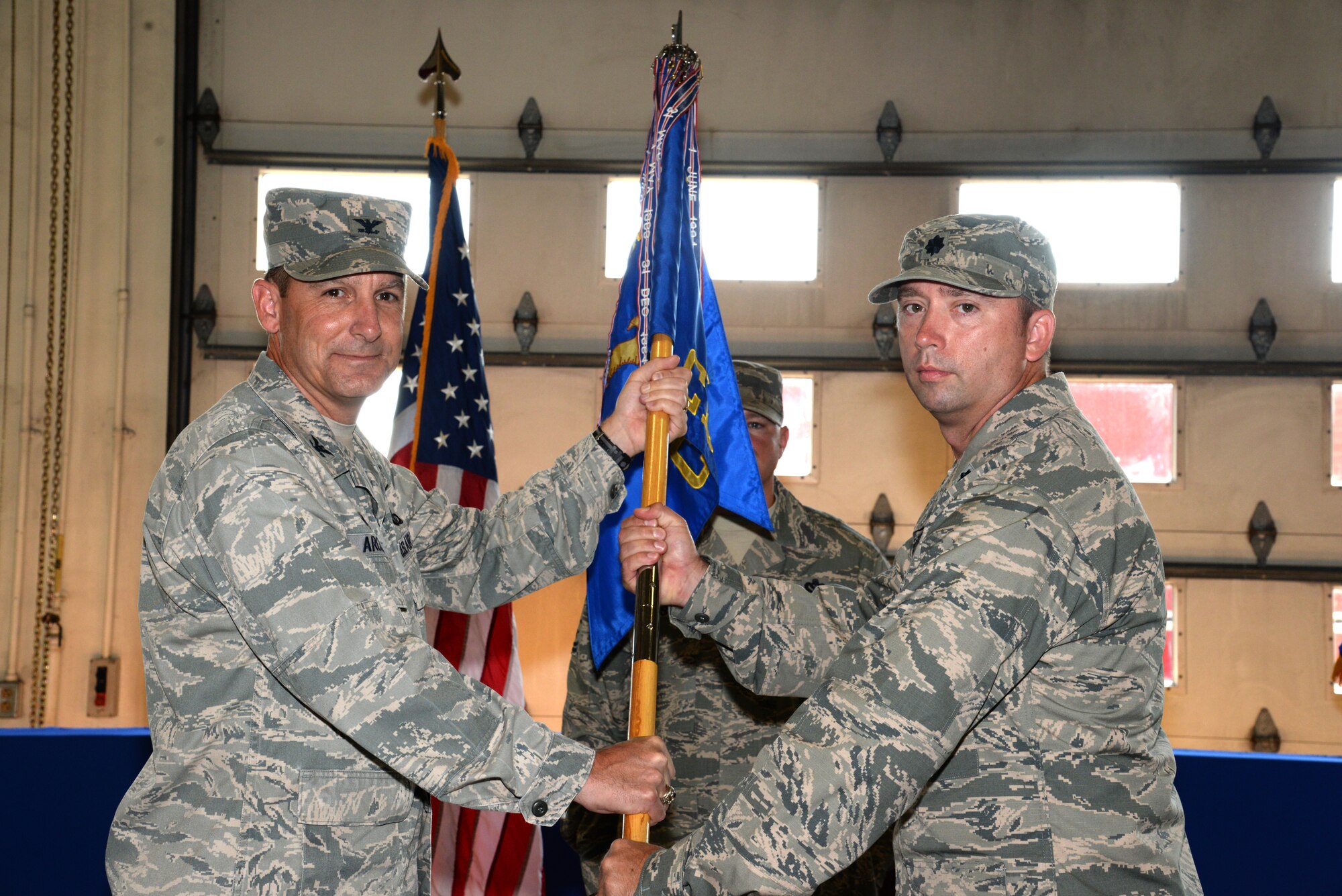 U.S. Air Force Lt. Col. Christopher Carter, 20th Civil Engineer Squadron commander (right), receives the 20th CES guidon from Col. Scott Arcuri, 20th Mission Support Group commander, during a change of command ceremony at Shaw Air Force Base, S.C., Aug. 20, 2014. The passing of the guidon is a military tradition that symbolizes the incoming commander’s authority and responsibility for his Airmen. (U.S. Air Force photo by Airman 1st Class Jonathan Bass/Released)