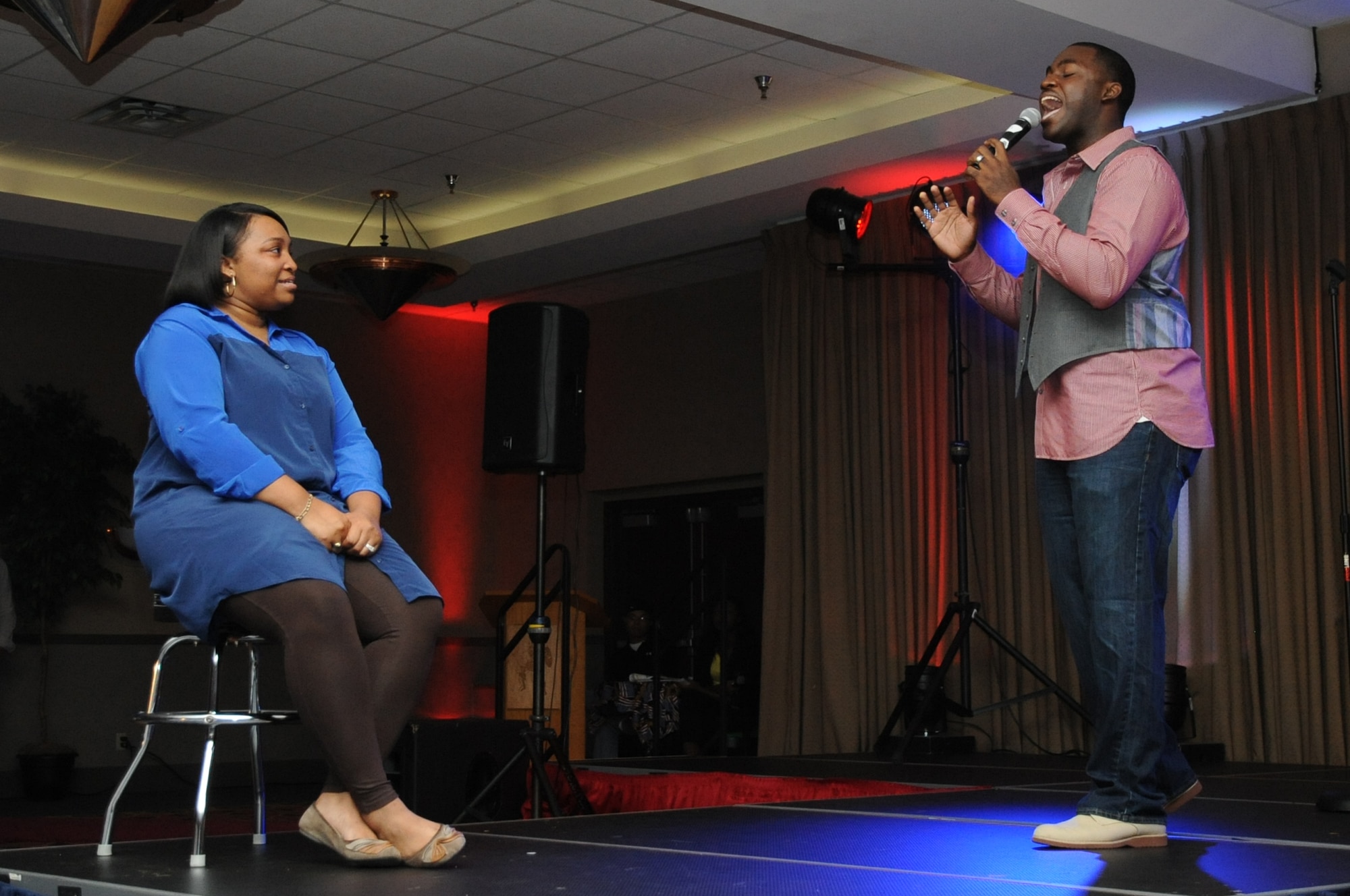 Senior Airman Andrew Hicks, 319th Medical Operations Squadron, sings ?So High? by John Legend to his wife Jalincia during the AMC Icon singing competition at the Northern Lights Club on Grand Forks Air Force Base, Aug. 22, 2014. Hicks won first prize for the third year in a row, besting 14 other competitors. (U.S. Air Force photo/Staff Sgt. David Dobrydney)