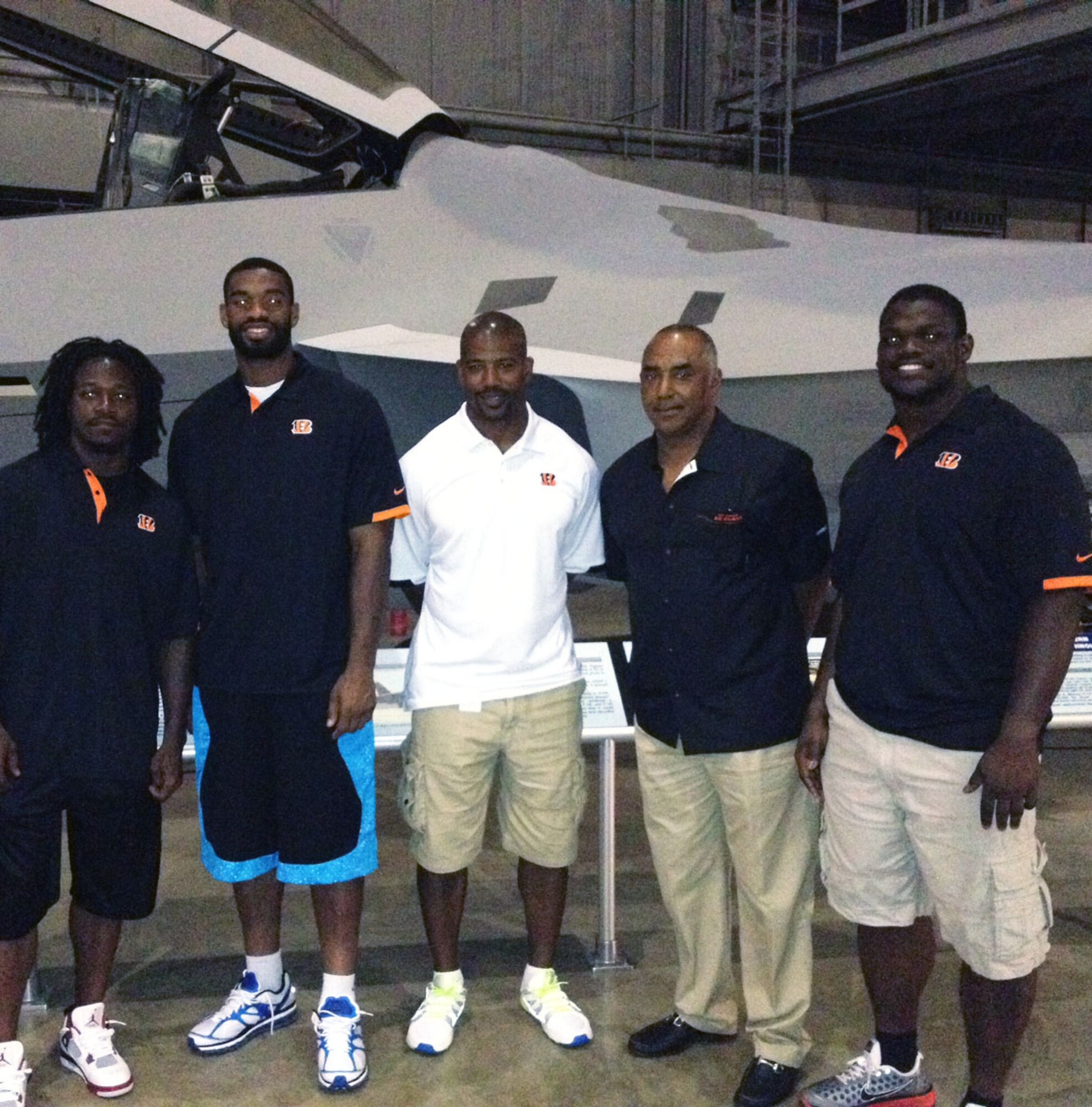 DAYTON, Ohio -- Members of the Cincinnati Bengals organization, (from left) Cornerback Adam Jones, Tight End Jermaine Gresham, former Running Back and current Director of Player Relations Eric Ball, Head Coach Marvin Lewis and Defensive Tackle Geno Atkins, took a group shot in from of the F-22A in August 2012. (U.S. Air Force photo)