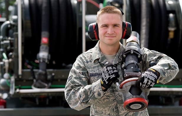 Airman 1st Class Christopher Baughan, 436th Logistics Readiness Squadron mobile fuels distribution operator unravels a hose on a R-12 hydrant fuel servicing vehicle Aug. 18, 2014, at Dover Air Force Base, Del. Baughan was randomly selected for The Airlifter's feature "A face of Team Dover: Vol. 1, No. 2." (U.S. Air Force photo by Roland Balik)