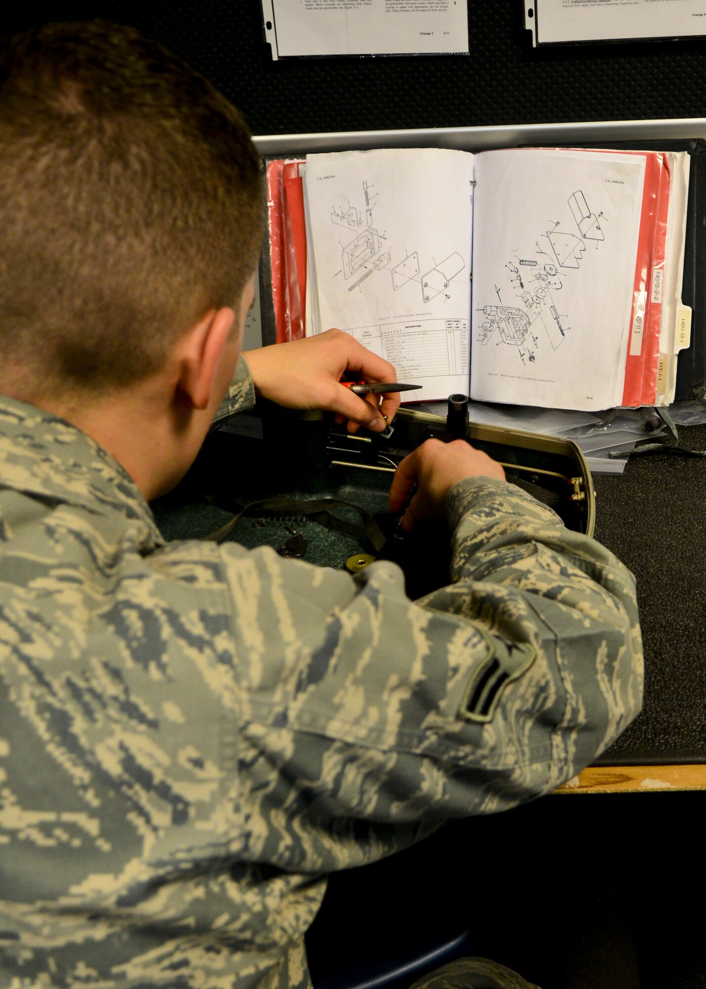 U.S. Air Force Airman 1st Class Patrick Long, 1st Operations Support Squadron Aircrew Flight Equipment apprentice, performs an annual check on a survival kit at Langley Air Force Base, Va., Dec. 20, 2013.  AFE specialists ensure aircrews understand the purpose, operation, care and use of their equipment and are prepared to deploy. Long Meadville, Pennsylvania (U.S. Air Force photo by Airman 1st Class Victoria H. Taylor/ Released)