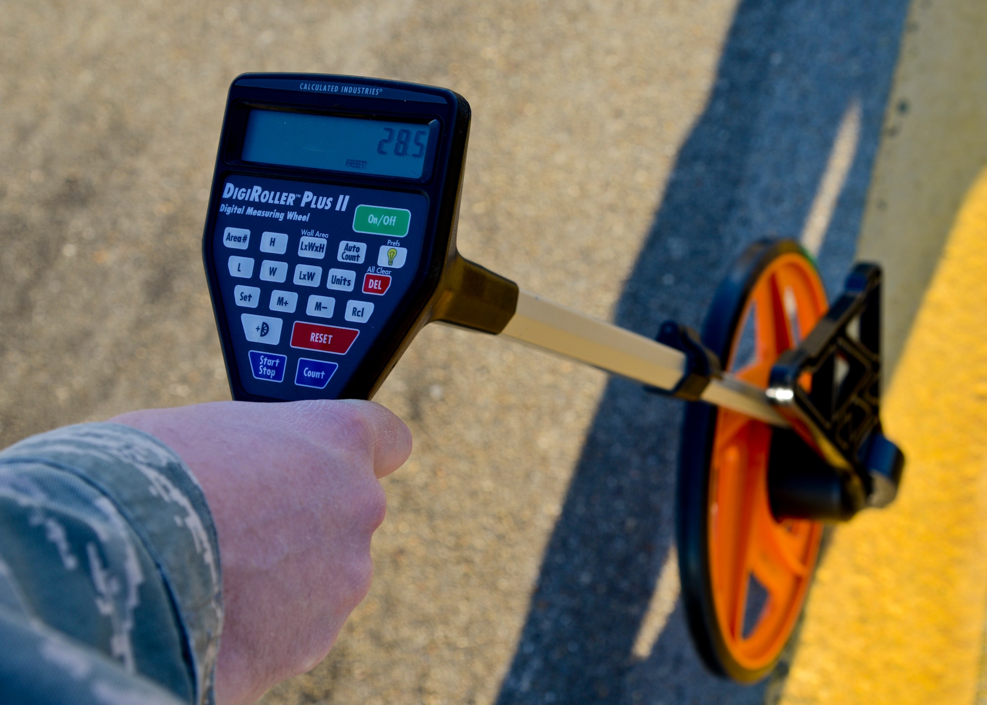 U.S. Air Force Airman 1st Class James Brady, 1st Operations Support Squadron Airfield Management operation coordinator, measures sections of the flight line with a digital measuring wheel at Langley Air Force Base, Va., Dec. 17, 2013.  Airfield management uses multiple tools to ensure the safety of the airfield and aircraft. Brady hails from Liberty, North Carolina. (U.S. Air Force photo by Airman 1st Class Victoria H. Taylor/ Released)
