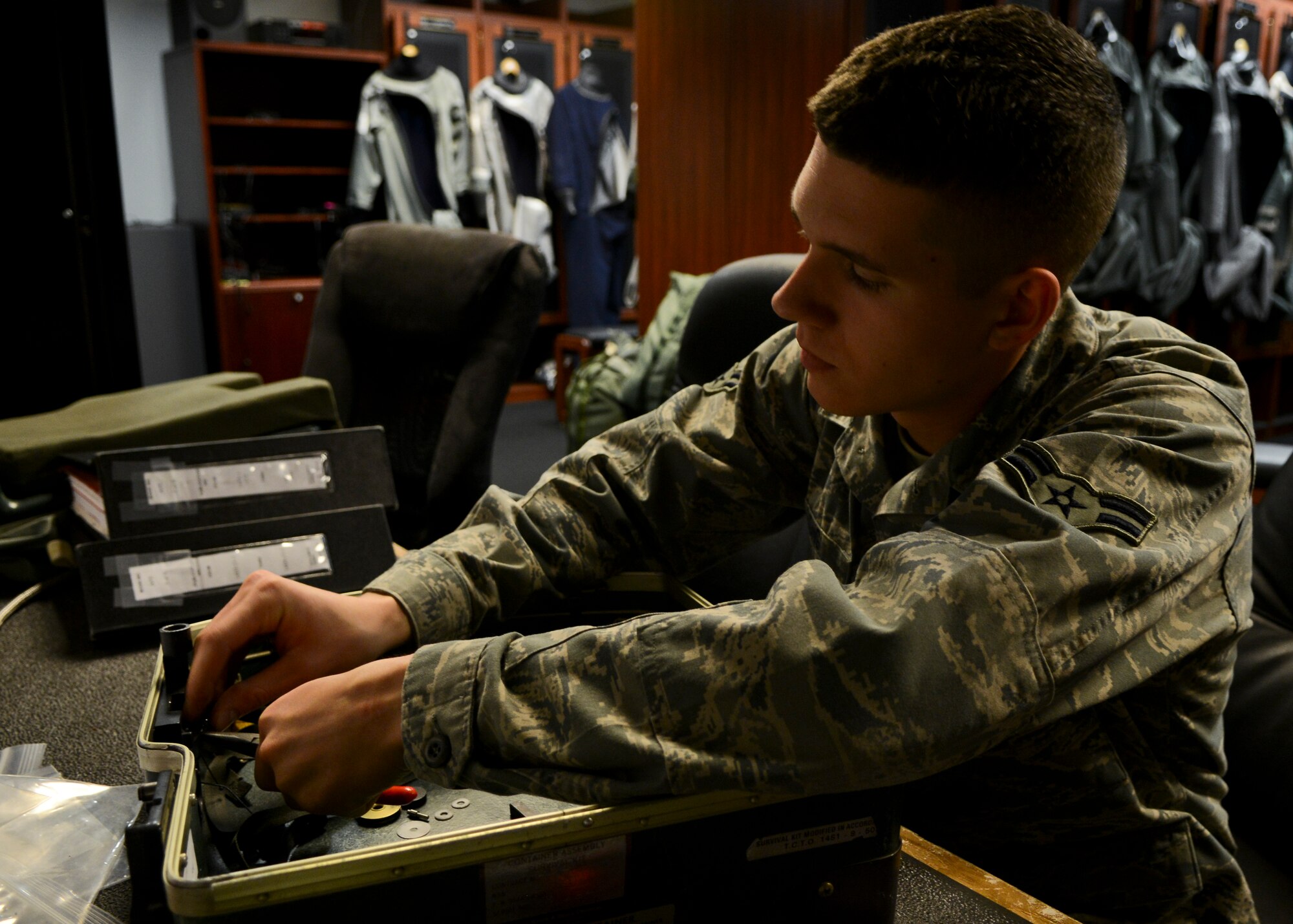 U.S. Air Force Airman 1st Class Patrick Long, 1st Operations Support Squadron Aircrew Flight Equipment apprentice, performs an annual check on a survival kit at Langley Air Force Base, Va., Dec. 20, 2013.  AFE specialists are responsible for helmets, oxygen masks, parachutes, flotation devices, survival kits, night vision goggles and other types of AFE equipment. Long hails from (U.S. Air Force photo by Airman 1st Class Victoria H. Taylor/ Released)