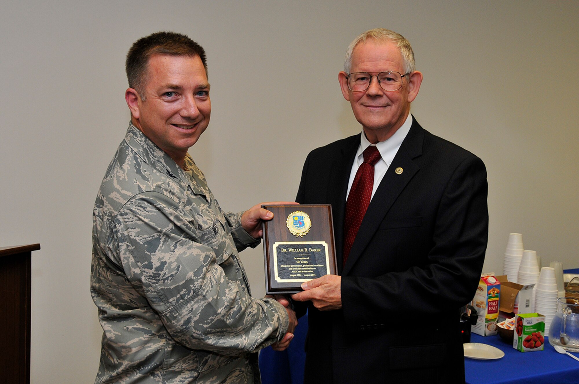 Col. Timothy West, the chief of the Arnold Engineering Development Complex (AEDC) Test Operations Division, presents a 50-year service recognition plaque to Dr. Bill Baker, an AEDC Fellow and branch chief in the AEDC Test Operations Division Analysis and Evaluation Branch, at a recent celebration in honor of Baker. (Photo by Rick Goodfriend)