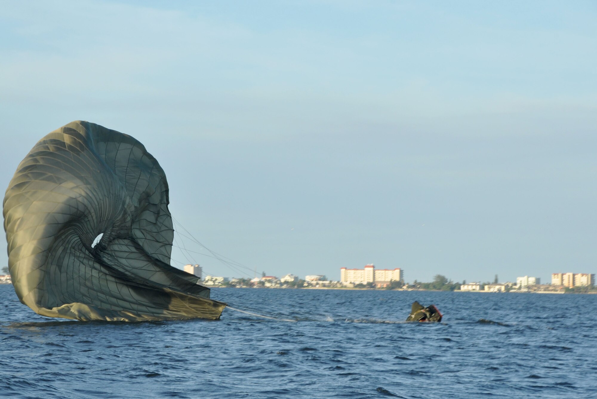 A rigging alternate method zodiac (RAMZ), a packaged cargo cube containing an inflatable, motorized Zodiac boat that is dropped from a plane, lands in the water off the coast of Patrick Air Force Base, Fla, August 19, 2014. Reserve Aircrew Flight Equipment specialists from the 308th Rescue Squadron, pack, maintain and inspect parachutes and package cargo to be dropped from aircraft. (U.S. Air Force photo/ Tech. Sgt. Katie Spencer) 