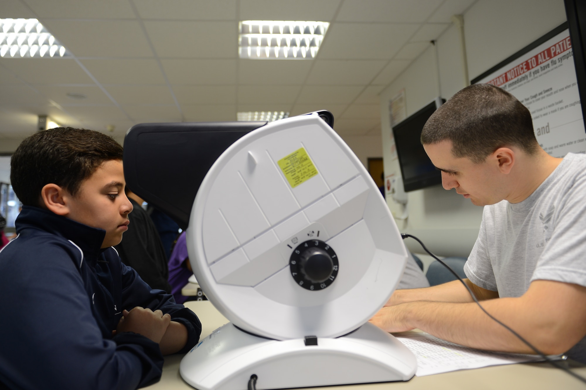 Airman 1st Class Daniel Suisse, 86th Aeromedical Squadron medical technician, administers a vision test to a child during Sports Physical Day hosted by the 86th Medical Group on Ramstein Air Base, Germany, Aug. 16, 2014. The medical group scheduled 440 free appointments, saving families in the Kaiserslautern Military Community $33,000 in medical expenses. (U.S. Air Force photo/Airman 1st Class Michael Stuart)