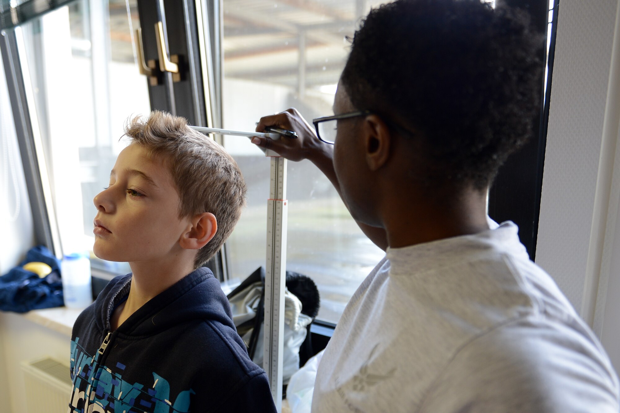 Staff Sgt. Shelise Harmon, 86th Medical Operations Squadron physical therapy technician, checks the height and weight of a patient during Sports Physical Day hosted by the 86th Medical Group on Ramstein Air Base, Germany, Aug. 16, 2014. The medical group scheduled 440 free appointments, saving families in the Kaiserslautern Military Community $33,000 in medical expenses. (U.S. Air Force photo/Airman 1st Class Michael Stuart) 