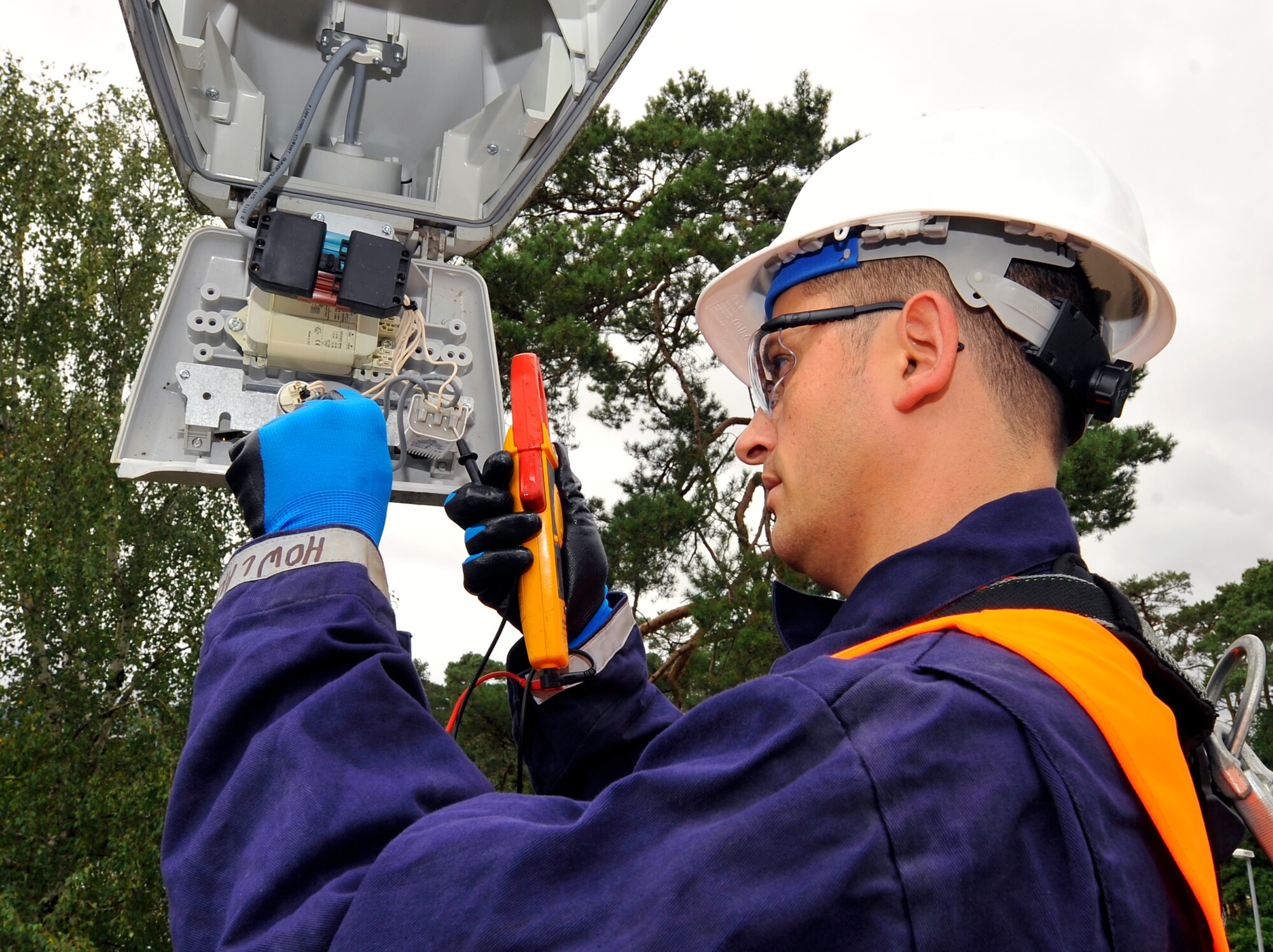 After de-energizing the street-light circuit, Tech. Sgt. Jason Howland, 786th Civil Engineer Squadron NCO in charge of exterior electrical systems, ensures the capacitor is completely discharged before repairing the inoperative fixture on Aug. 15, 2014 at Ramstein Air Base, Germany. A three-man team worked three weeks to repair and replace lights and circuits to maintain safety on Ramstein during dark hours. (U.S. Air Force photo/Airman Larissa Greatwood)