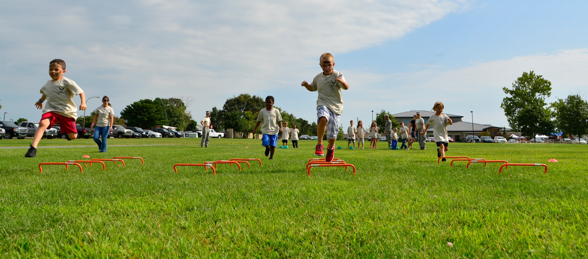 Children participating in Operation KUDOS, Kids Understanding Deployment Operations, jump over obstacles Aug. 20, 2014, at the Youth Center on Dover Air Force Base, Del. Children were tasked with going through a multi-stage obstacle course to simulate some of the stresses their parents face when being deployed. (U.S. Air Force photo/Airman 1st Class William Johnson)