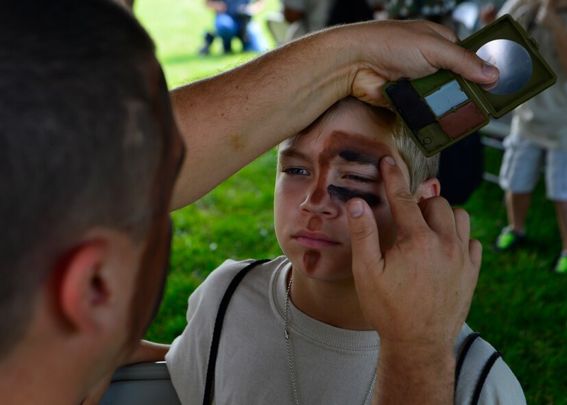Aiden Weil, son of Tech. Sgt. Jeannie Medeiros, 736th Aircraft Maintenance Squadron, receives war paint during Operation KUDOS, Kids Understanding Deployment Operations Aug. 20, 2014, at the Youth Center on Dover Air Force Base, Del. Children got their face painted before running through a multi-stage obstacle course. (U.S. Air Force photo/Airman 1st Class William Johnson)