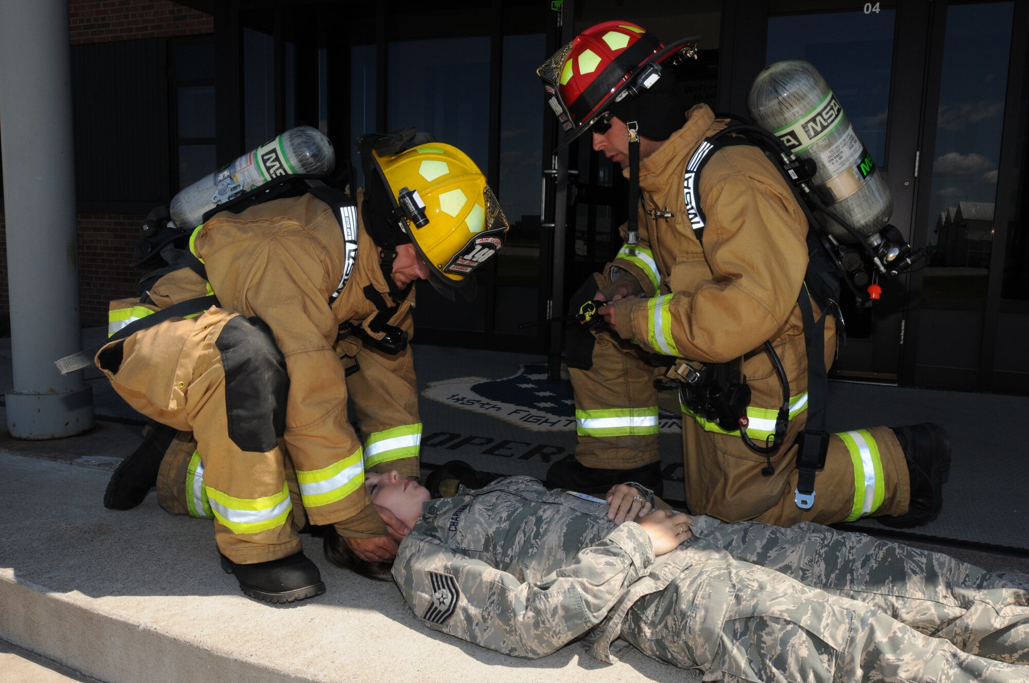 Two firefighters, from the  148th Fighter Wing, Minnesota Air National Guard, treat a simulated casualty for wounds Aug. 12, 2014 during a recent natural disaster preparedness response exercise in Duluth, Minn.  The Wing, along with other Minnesota National Guard units and civilian agencies jointly participated in the state-wide Vigilant Vortex exercise.  (U.S. Air National Guard photo by Tech. Sgt. Brett R. Ewald/Released)