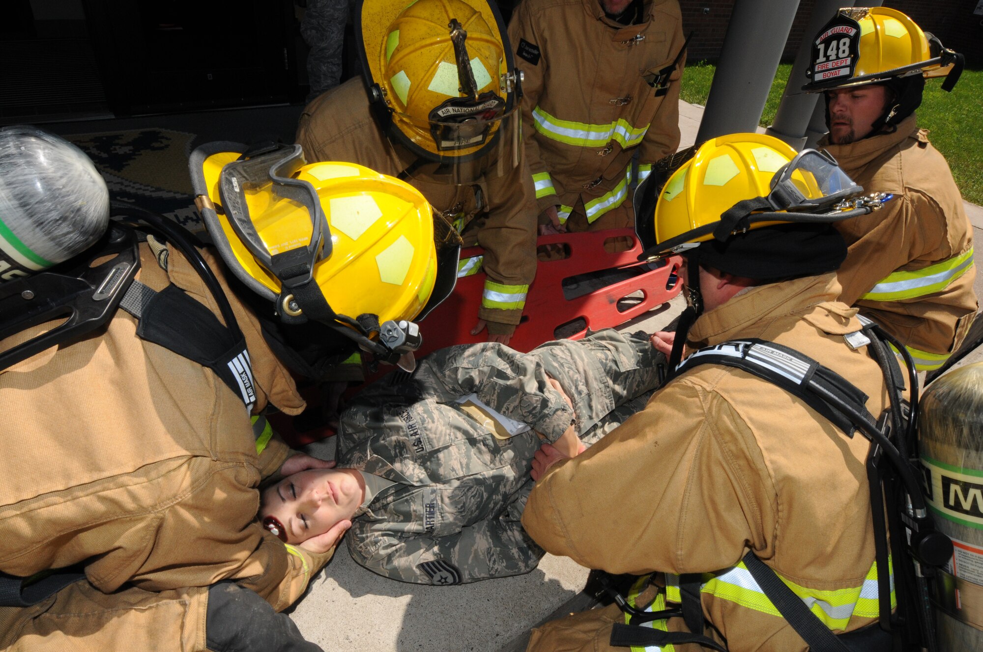Firefighters from the 148th Fighter Wing, Minnesota Air National Guard, prepare to move a simulated casualty onto a backboard for evacuation Aug. 12, 2014 during a recent natural disaster preparedness response exercise in Duluth, Minn.  The Wing, along with other Minnesota National Guard units and civilian agencies jointly participated in the state-wide Vigilant Vortex exercise.  (U.S. Air National Guard photo by Tech. Sgt. Brett R. Ewald/Released)