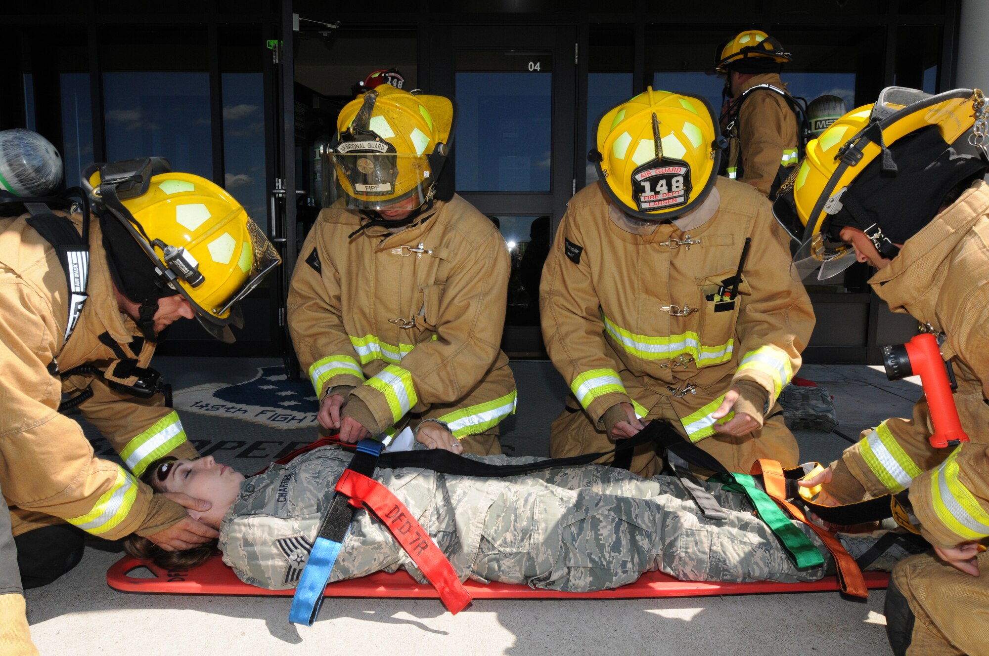 Firefighters from the 148th Fighter Wing, Minnesota Air National Guard, secure a simulated casualty onto a backboard prior to evacuation Aug. 12, 2014 during a recent natural disaster preparedness response exercise in Duluth, Minn.  The Wing, along with other Minnesota National Guard units and civilian agencies jointly participated in the state-wide Vigilant Vortex exercise.  (U.S. Air National Guard photo by Tech. Sgt. Brett R. Ewald/Released)