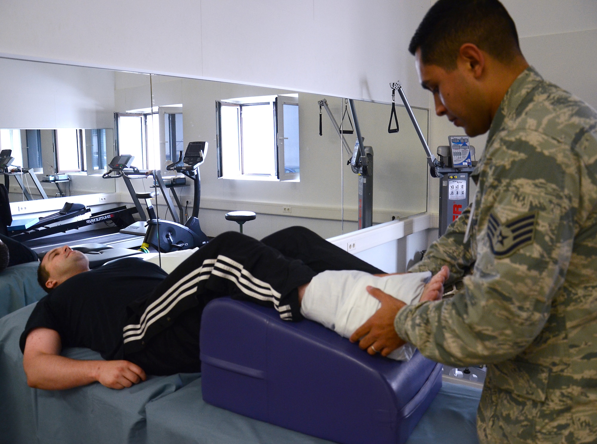 Staff Sgt. Mario Jimenez, 86th Medical Operations Squadron Physical Therapy technician, applies an ice pack to the ankle of Senior Airman James Harrod, 693rd Intelligence, Surveillance and Reconnaissance Group operations training manager, at the end of a physical therapy session at Ramstein Air Base, Germany, Aug. 19, 2014. Without formal treatment and physical therapy, service members run the risk of re-injuring themselves and causing greater damage to an area. (U.S. Air Force photo/Senior Airman Timothy Moore)