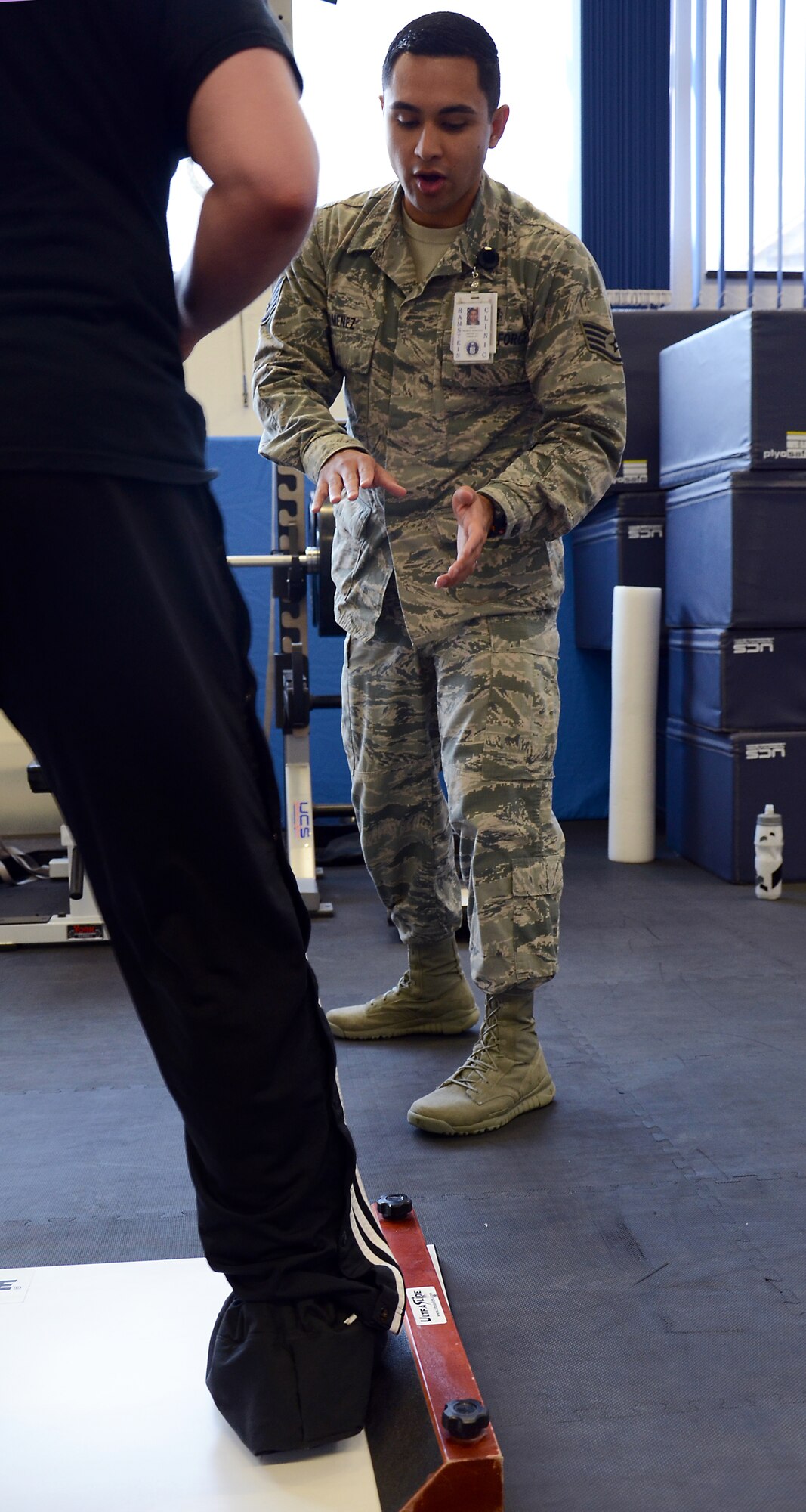 Staff Sgt. Mario Jimenez, 86th Medical Operations Squadron Physical Therapy technician, explains the purpose of an exercise to Senior Airman James Harrod, 693rd Intelligence, Surveillance and Reconnaissance Group operations training manager, during a physical therapy session at Ramstein Air Base, Germany, Aug. 19, 2014. The physical therapy clinic at Ramstein conducts an average of 200 to 250 sessions a week. (U.S. Air Force photo/Senior Airman Timothy Moore)