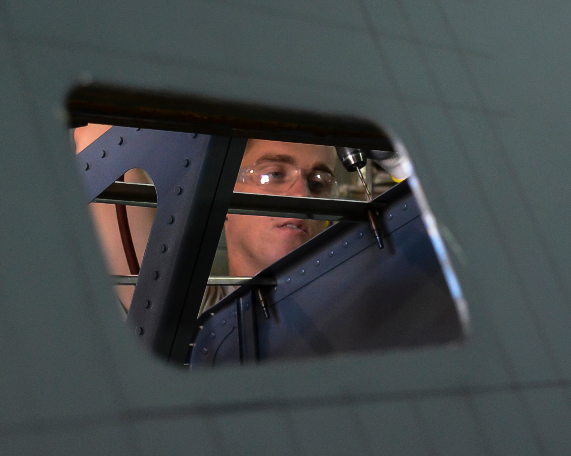 Senior Airman Ethan Pollock drills a hole to add another rivet to the simulated aircraft structure being built by the 507th Air Refueling Wing fabrication flight's sheet metal shop. Tech. Sgt. Harold Fulghum came up with the idea to build the simulator. It gives sheet metal workers the opportunity to work on the leading edge of a KC-135R Stratotanker wing without the jet actually being broken. (U.S. Air Force photo/Senior Airman Mark Hybers) 
