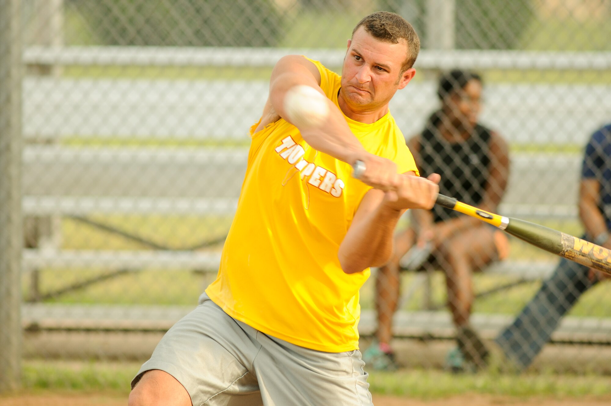 Thumper coach and player Joe Brown prepares to launch the softball into the outfield August 18 during a game against the 507th Air Refueling Wing Okies. The Thumpers gained two more wins against the Okies in their long rivalry, widening the series lead. (Air Force photo/Staff Sgt. Caleb Wanzer)