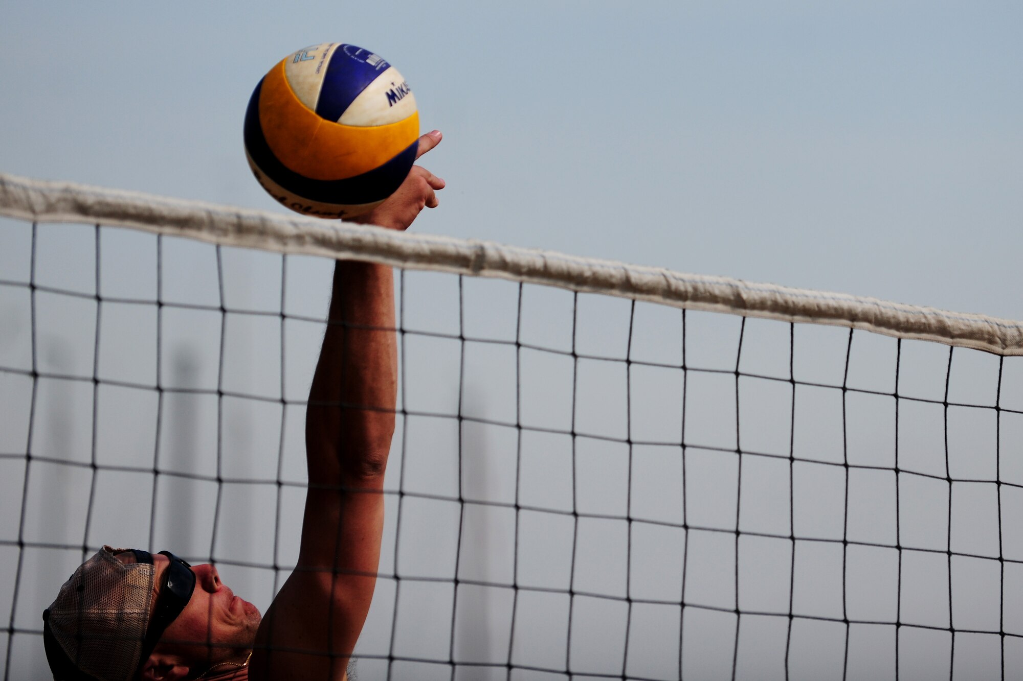 U.S. Air Force Lt. Col. Barry King II, 37th Airlift Squadron detachment commander, spikes a volleyball over a net during a barbecue hosted by Polish Army soldiers at Powidz Lake, Poland, Aug. 22, 2014. The barbecue allowed Service members from both nations to joint together and celebrate the long-standing bond their countries share. (U.S. Air Force photo by Staff Sgt. Jarad A. Denton/Released)