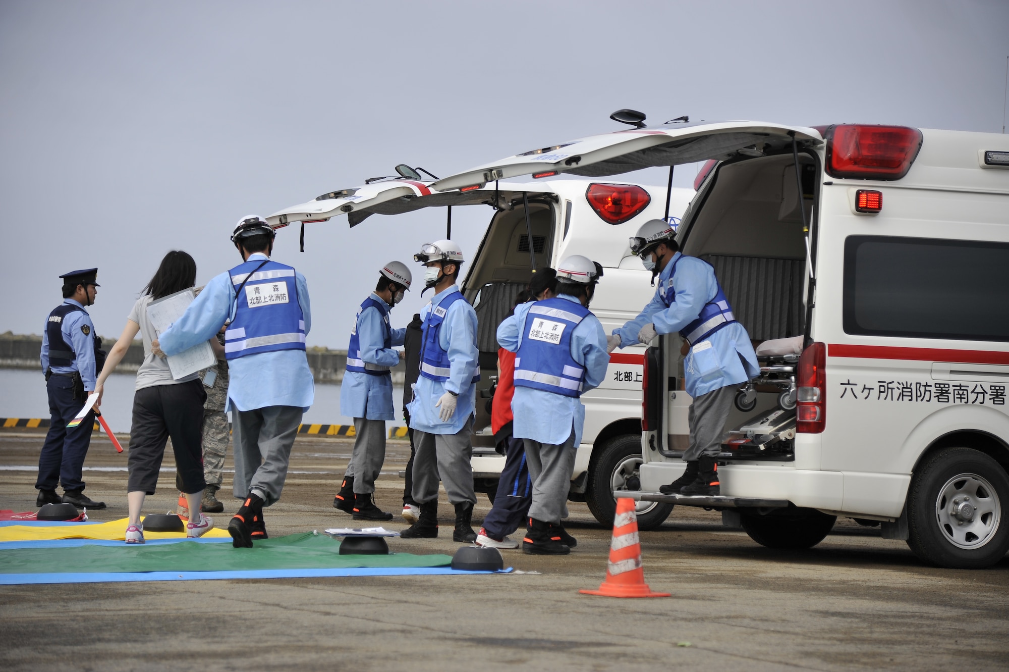 Members from Rokkasho Village fire department assist simulated injured civilians during a Major Accident Response Exercise at Rokkasho Village, Japan, Aug. 19, 2014. Rokkasho fire department arrived on the scene and set up a triage for the wounded after a simulated F-16 Fighting Falcon crash landed in the Mutsu Ogawara port. (U.S. Air Force photo by Airman 1st Class Patrick S. Ciccarone/Released)