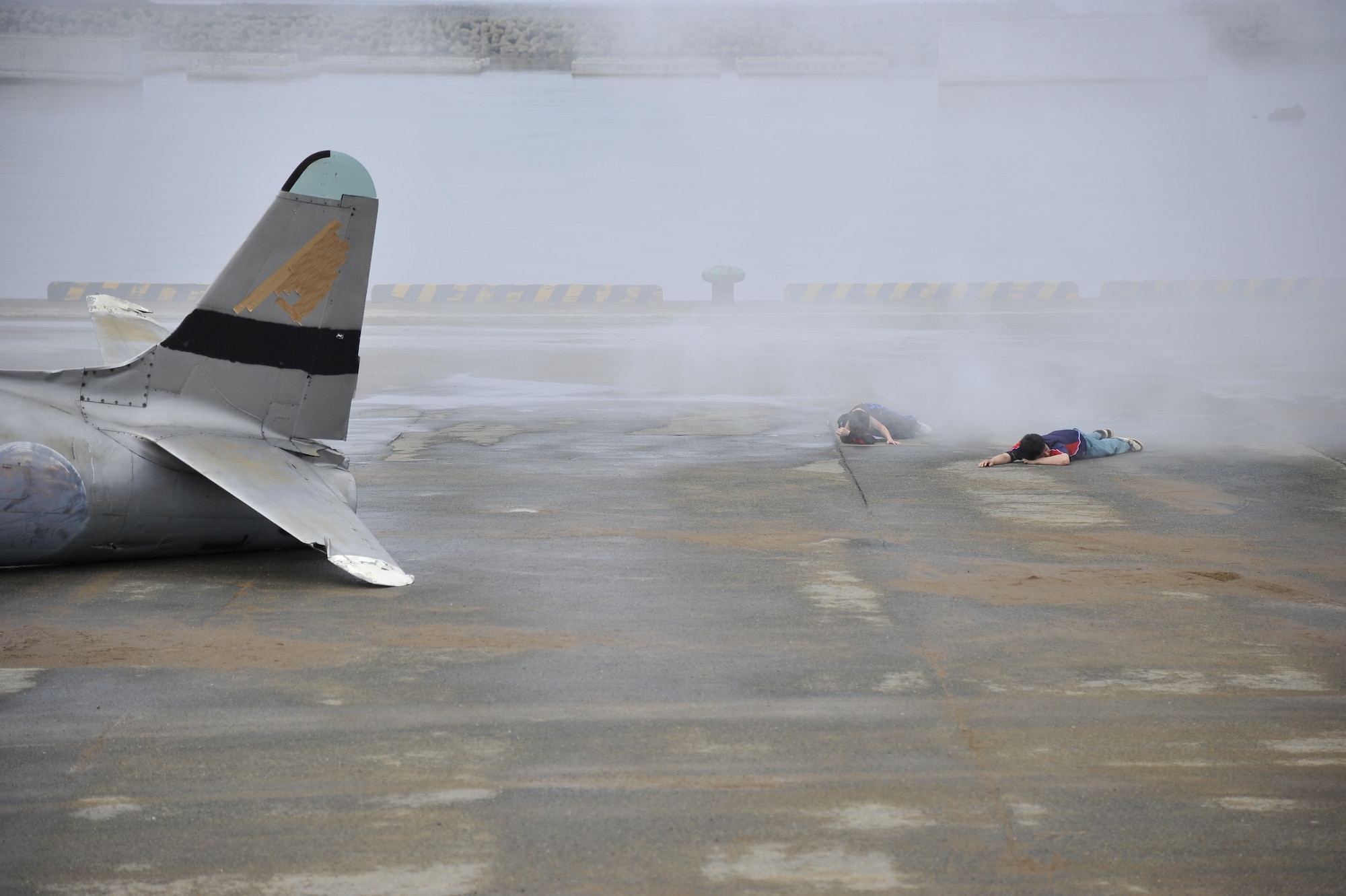Two simulated victims lay at a crash site of an F-16 Fighting Falcon during a Major Accident Response Exercise at Rokkasho Village, Japan, Aug. 19, 2014. The scenario involved an F-16 crashing into a nearby village injuring 11 civilians, a building fire and two fishermen and a pilot adrift at sea. (U.S. Air Force photo by Airman 1st Class Patrick S. Ciccarone/Released)
