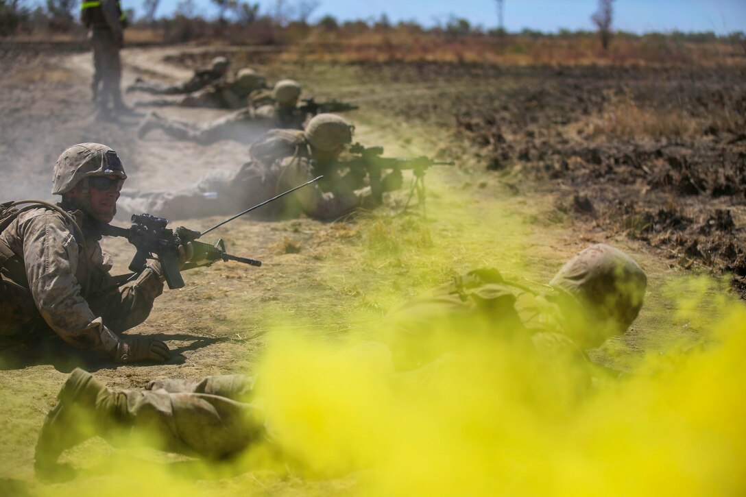 U.S. Marines fire their weapons under the cover of smoke during an assault on an enemy position during Exercise Koolendong on Bradshaw Training Area, Australia, Aug. 16, 2014.