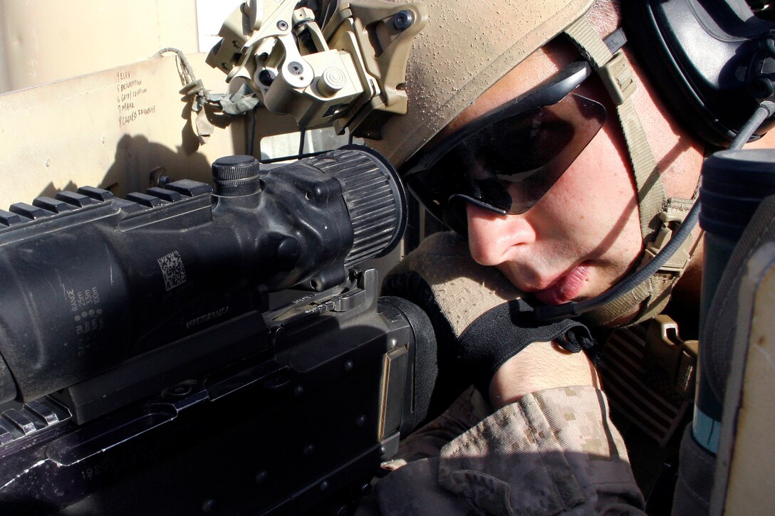 U.S. Marine Corps Cpl. Steven Peterson uses the optic lens on his weapon to scan the area as he provides security during an operation in Helmand province, Afghanistan, Aug. 16, 2014. Peterson is a forward fires observer assigned to the 1st Air Naval Gunfire Liaison Company.