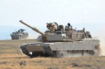 An M1A2 SEP Abrams from 116th Cavalry Brigade Combat Team, Idaho Army National Guard (middle) and a M1134 Anti-Tank Guided Missile Vehicle from 1st Squadron, 14th Infantry Regiment, 3rd Stryker Brigade Combat Team, Joint Base Lewis-McChord, Washington, return from waging mock battle against one another during an eXportable Combat Training Capability exercise, at Orchard Combat Training Center, south of Boise, Idaho, Aug. 14, 2014.