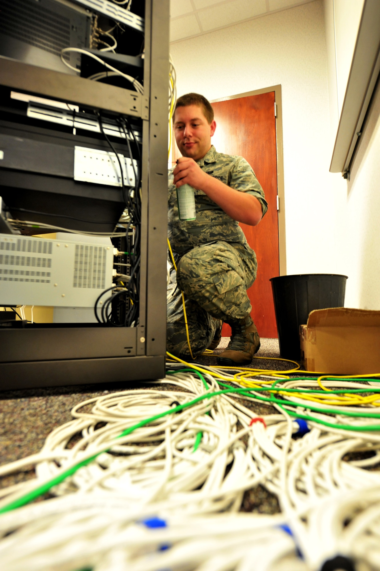 Senior Airman Lee Owens, former 42nd Air Base Wing broadcast engineer, sprays compressed air on television equipment, July 24, 2014. After entering the Air Force at age 22, Owens is rejoining the civilian workforce. The Massachusetts native is one of more than 3,500 Airmen selected for separation during the first Quality Force Review Board. (U.S. Air Force photo by Master Sgt. Michael Voss)  