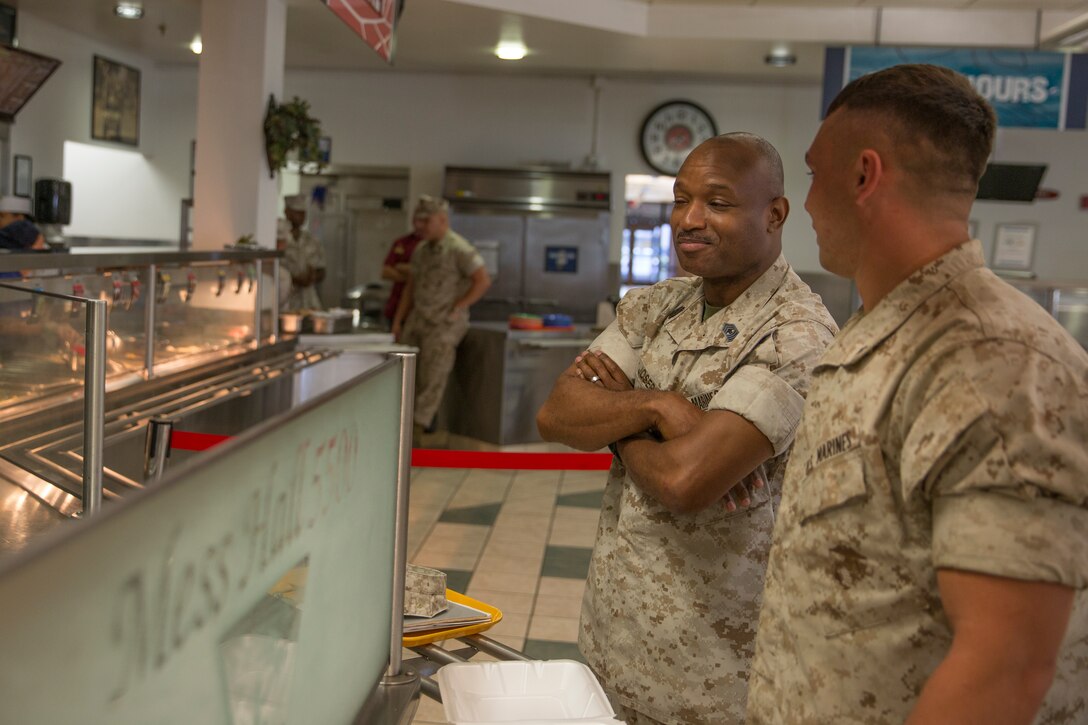 Master Gunnery Sgt. Eric Joseph, food service technician and inspector for the Best of the West competition, speaks to a Marine as he waits for his food during an inspection for the competition aboard Marine Corps Air Station Miramar, Calif., Aug. 26. Mess hall scores will be compared to other mess halls in the region to see which moves on to compete in the Best in the Marine Corps competition.