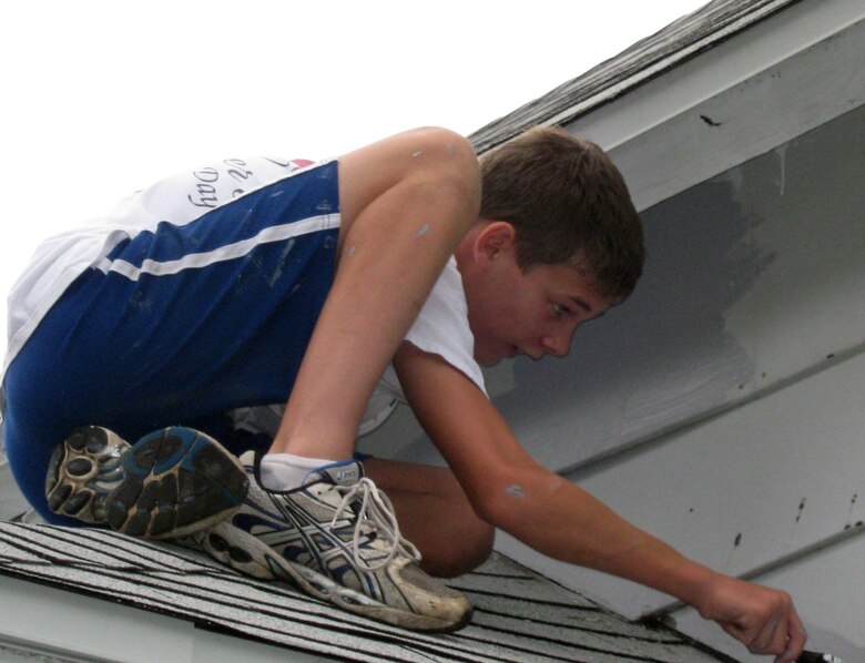 Greg Cross, son of Omaha District Commander, shows the flexibility needed to get into some of the tighter and harder to reach parts of the two-story home being refreshed on Paint-A-Thon day. 