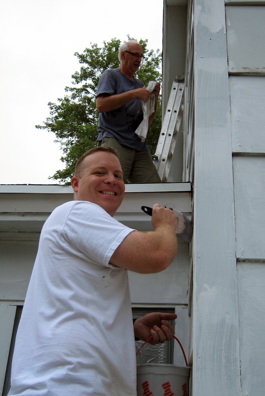 Jim Pakiz, Assistant District Counsel and a member of the 2014 Omaha District Leadership Development Class, paints the lower section of the house, while John Remus, Hydrologic Engineering Branch Chief, gets the higher portions of the Paint-A-Thon house.