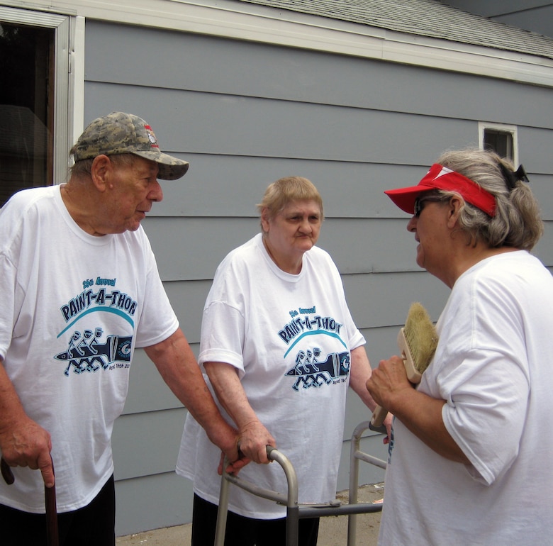 Joyce Ridout, Brush Up Nebraska Paint-A-Thon team leader, reveals the completed home to its homeowners in Council Bluffs, Iowa, Erich and Arlene Schwartz.