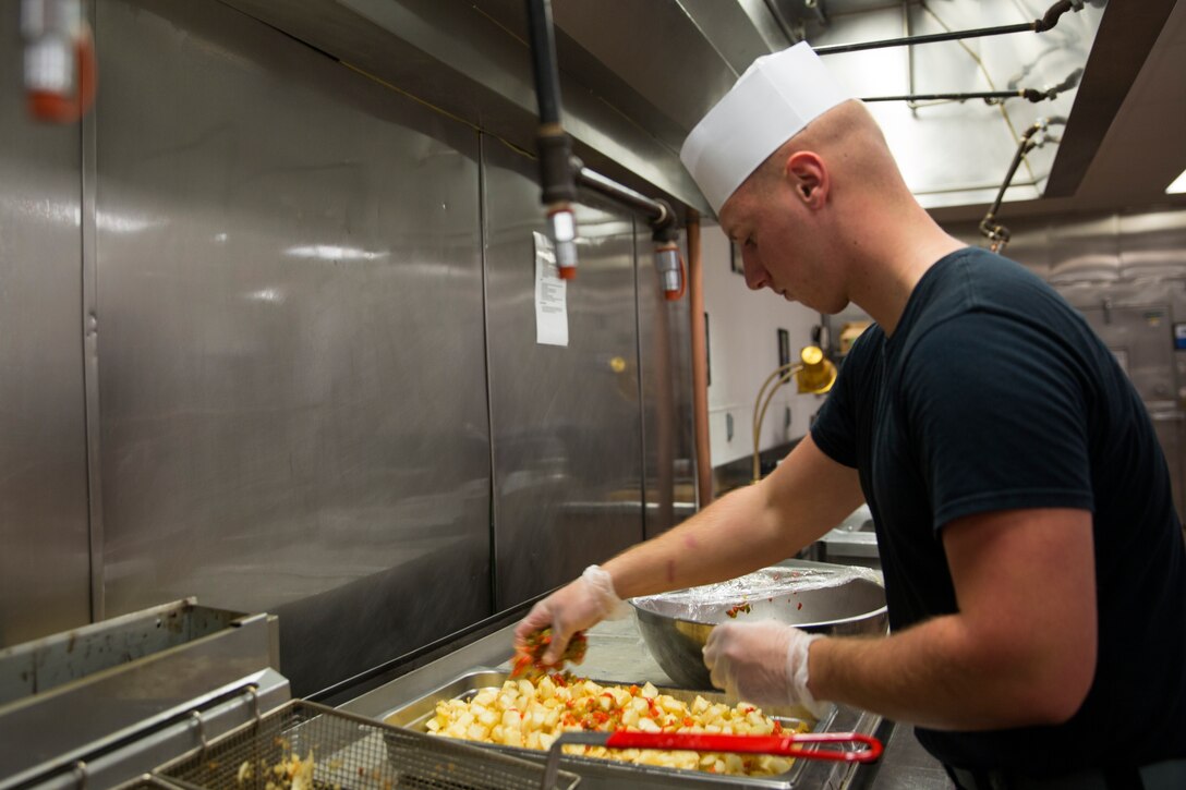 Lance Cpl. Timothy McKnight, a food service technician at Gonzales Hall, adds peppers to potatoes for the breakfast line before an inspection for the Best of the West competition aboard Marine Corps Air Station Miramar, Calif., Aug. 26. The air station’s mess hall competed in and won the competition in fiscal years 2012, 2013, 2014, and hopes to regain the title for 2015.