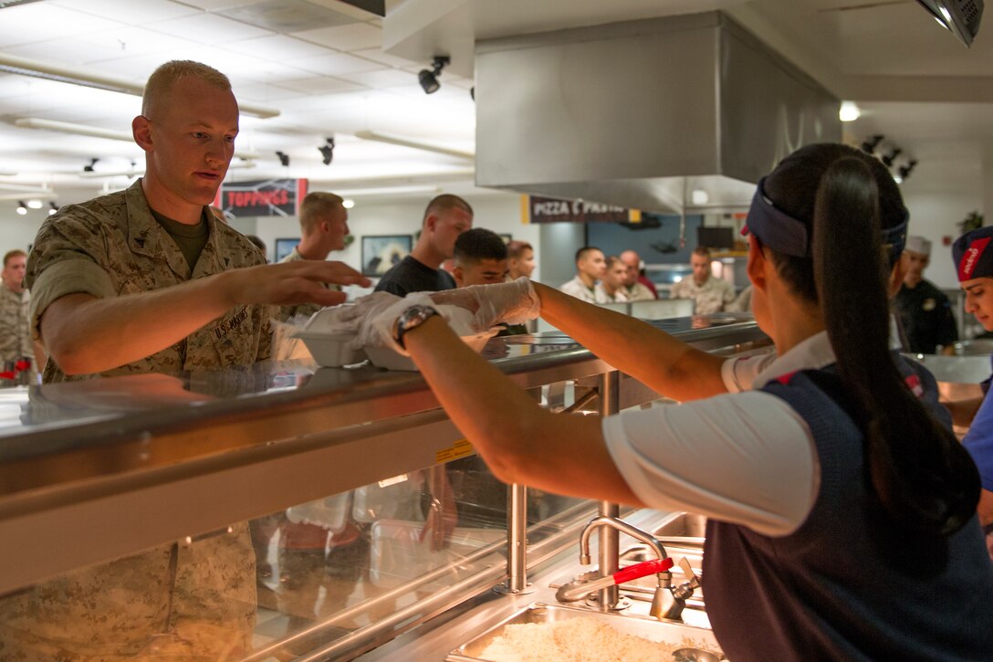 Aurora Fernandez, project manager of Gonzales Hall, serves food to Lance Cpl. David Witmer, a radio technician with Marine Wing Communications Squadron (MWCS) 38, during breakfast before an inspection for the Best of the West competition aboard Marine Corps Air Station Miramar, Calif., Aug. 26. Mess hall scores will be compared to other mess halls in the region to see which moves on to compete in the Best in the Marine Corps competition.