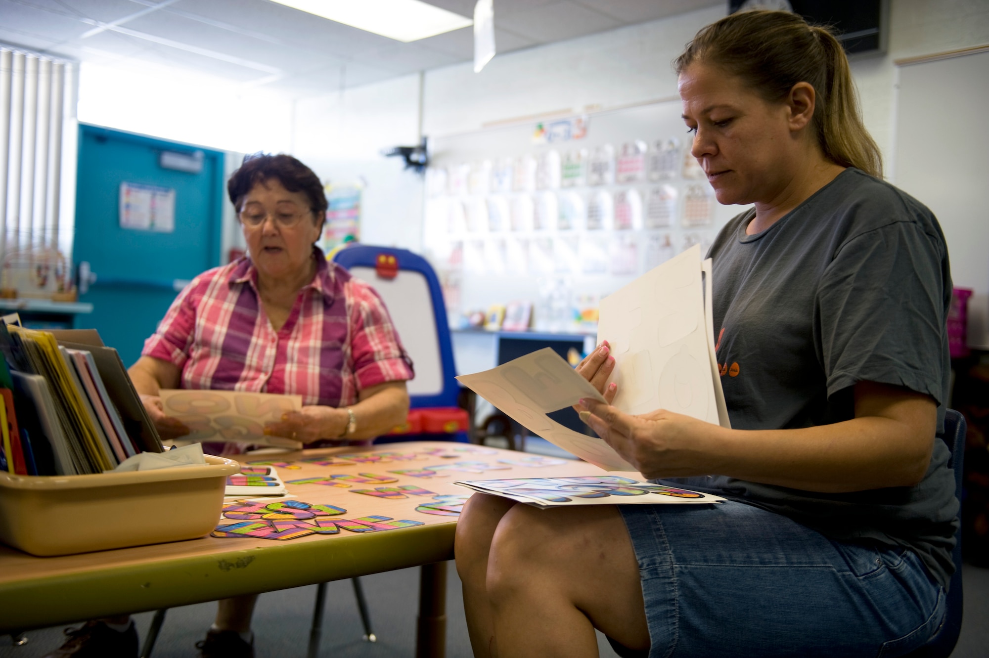 Dominga Romero (left), special programs teacher assistant, and Terri Gravnitz (right), early childhood special education teacher, prepare their classroom for the start of the new school year at Lomie G. Heard Elementary School on Nellis Air Force Base, Nev., Aug. 21, 2014. The new school year will include many opportunities for families to get involved with school activities, as well as teaching the children to love learning in a safe environment. (U.S. Air Force photo by Airman 1st Class Mikaley Towle)