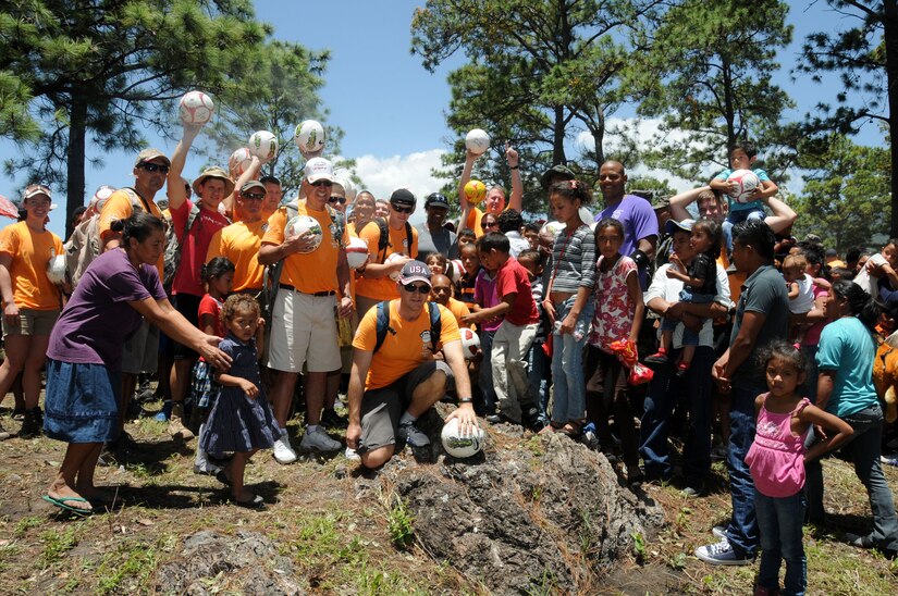 Service members give the village children some soccer balls that were donated by the non-profit organization Kick for Nick.  Over 130 members of Joint Task Force-Bravo, with the support of Joint Task Force-Bravo’s Joint Security Forces and Honduran Air Force cadets, hiked nearly eight miles round trip to deliver more than 2,700 pounds of food and supplies to families in need in the mountain village of Soso Mico outside La Paz, Honduras, Aug. 23, 2014.  The effort was part of the 56th Joint Task Force-Bravo Chapel Hike, a venerable tradition during which service members donate their money and time to purchase food and supplies and then tote them on a hike through the mountains to deliver to local, underserviced communities.  (Photo by U.S. Air National Guard Capt. Steven Stubbs)