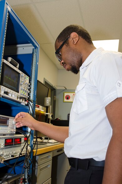 Elijah Blakemore, TMCF summer intern, programs a machine used at the AFRL Sensors Directorate. (U.S. Air Force photo/Mikee Huber)