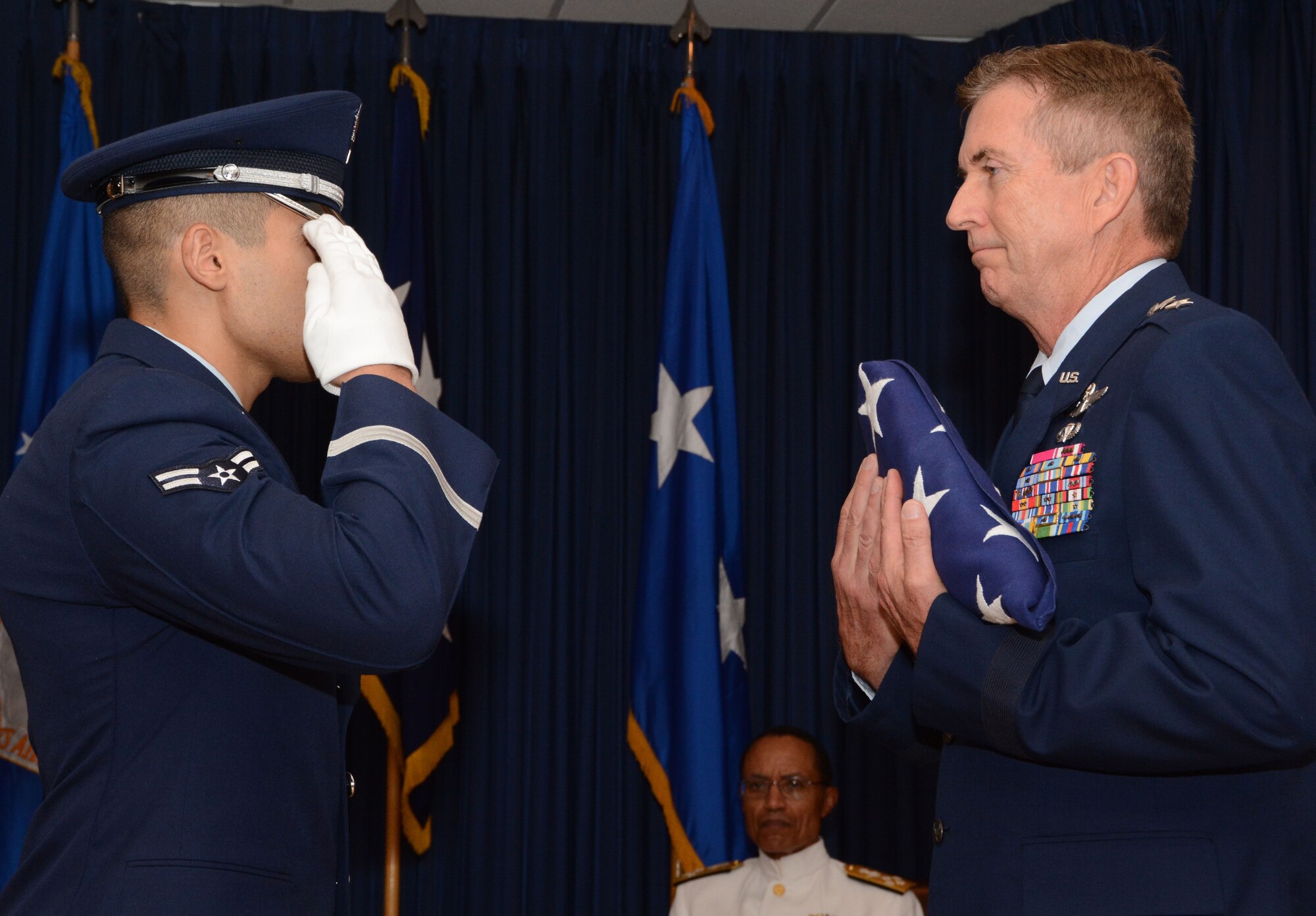 Maj. Gen. William Schauffert, Mobilization Assistant to the U.S. Strategic Command commander, receives a folded American flag from the 301st Joint Service Honor Guard member during his retirement ceremony August 22, 2014, at Naval Air Station Fort Worth Joint Reserve Base, Texas, as Adm. Cecil D. Haney, USSTRATCOM commander, looks on. USSTRATCOM, located at Offutt Air Force Base, Neb., is one of nine DoD unified combatant commands and is charged with strategic deterrence, space operations, cyberspace operations, joint electronic warfare, global strike, missile defense, intelligence, surveillance and reconnaissance, combating weapons of mass destruction, and analysis and targeting. (U.S. Air Force photo/Staff Sgt. Samantha Mathison)