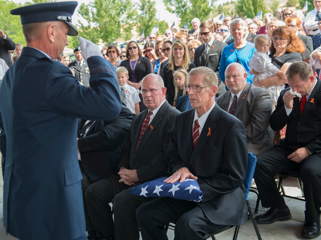 Maj. General Gary Sayler presents the United States flag to Brad Fisher at the Idaho State Veterans Cemetery August 25, 2014, at Boise, Idaho. While assigned to the 1st Air Commando Squadron at Pleiku, South Vietnam, he received nationwide publicity for his actions during the battle of A Shau Valley in which he rescued a downed pilot by landing his A-1E Skyraider on a shrapnel-ridden runway and under heavy ground fire. (U.S. Air Force photo by Airman 1st Class Malissa Lott/RELEASED) 