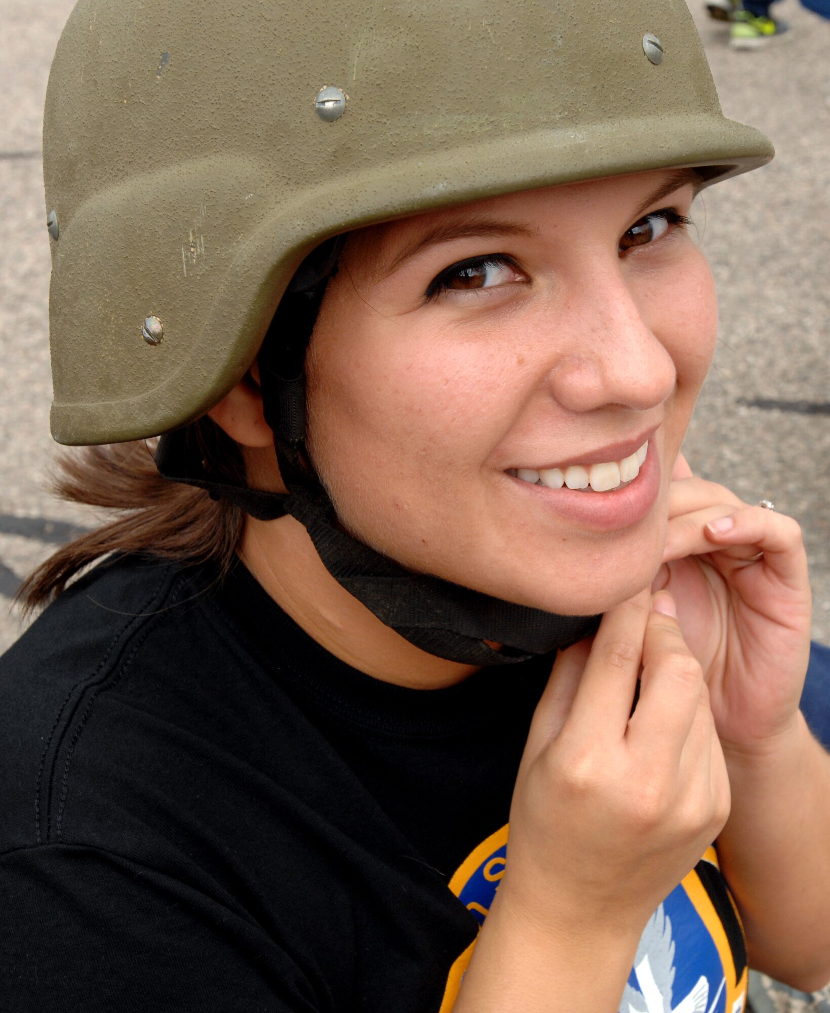 Senior Airman Ninoska Williams-Sequeira, 319th Security Forces Squadron, dons a flak helmet before the bed race during Summer Bash Aug. 21, 2014 on Grand Forks AFB, N.D.  Summer Bash is an annual event designed to boost morale and increase esprit de corps. (U.S. Air Force photo/Staff Sgt. Susan L. Davis)