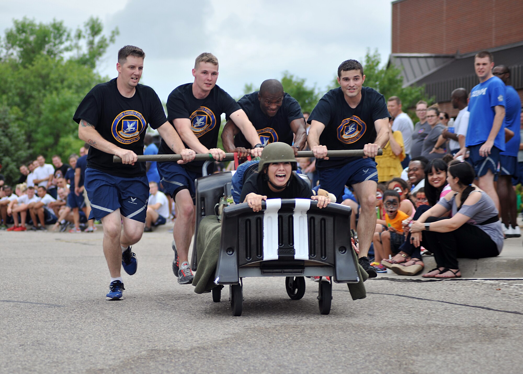 Members of the 319th Security Forces Squadron race toward the finish line during the Summer Bash bed race Aug. 21, 2014, on Grand Forks Air Force Base, N.D. The 319th SFS competed against 11 different squadrons and won first place for the large unit category with a time of 1 minute and 56.93 seconds. (U.S. Air Force photo/Senior Airman Xavier Navarro)